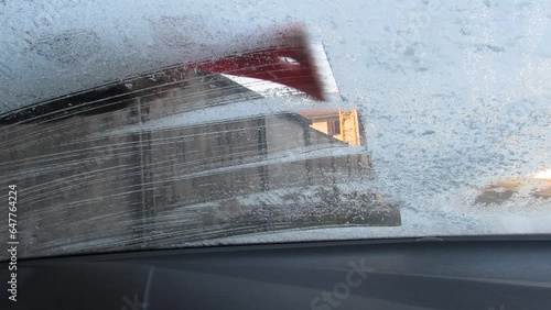 Togliere il ghiaccio dal parabrezza della macchina in inverno photo
