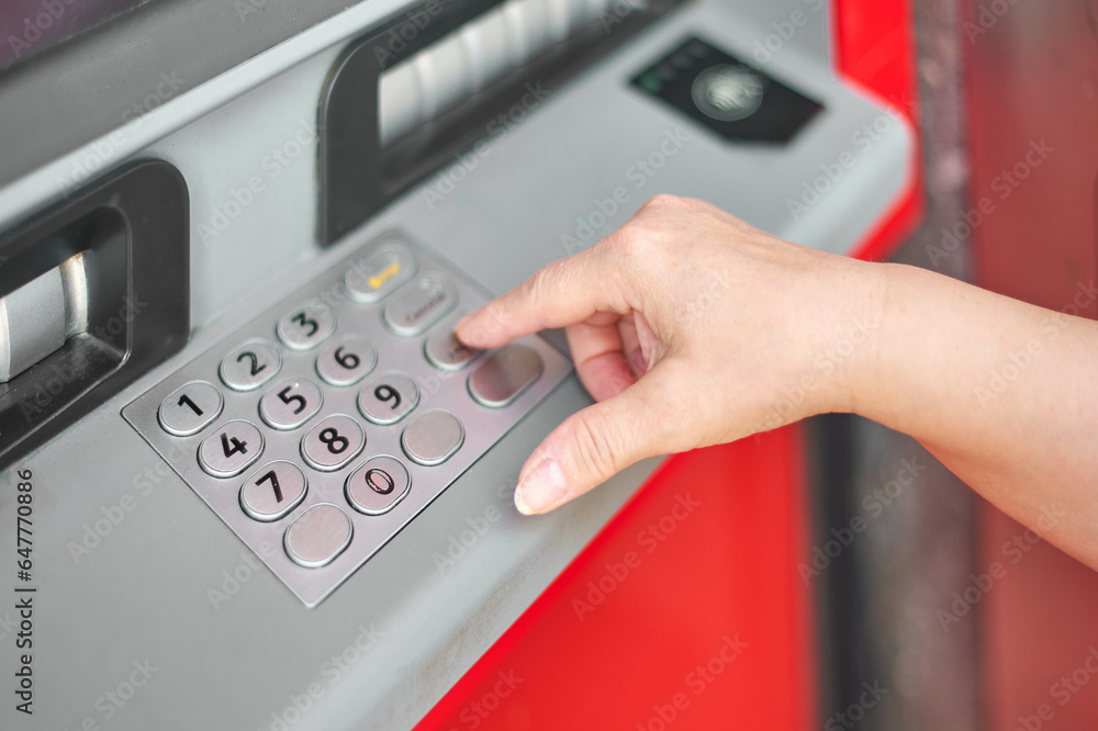 Hand of anonymous person putting the secret number in the bank's ATM to identify themselves and be able to withdraw money. Hand of anonymous person putting the secret number in the bank's ATM to identify themselves and be able to withdraw money.