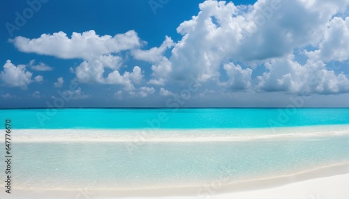 Sandy beach featuring white sand and rolling calm wave of turquoise ocean on sunny day  white clouds in blue sky background