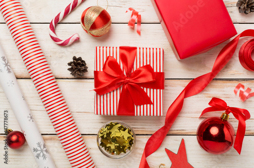 Gift boxes with paper's rools and christmas decoration on wooden background, top view