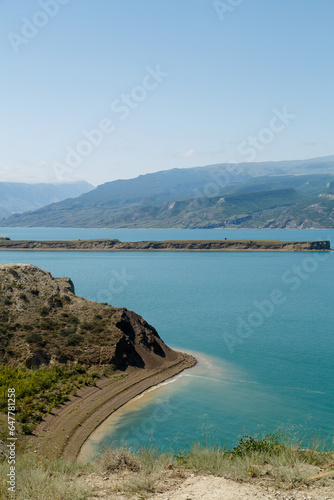 Mountain lake against the backdrop of mountains with lustrous water on a sunny day.