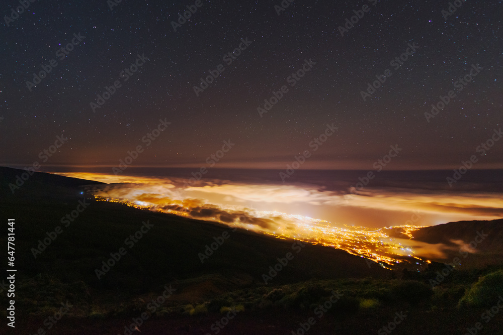 Night city covered by clouds, aerial view