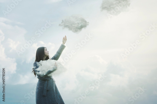surreal woman is releasing the clouds that she was holding in her arms into the sky, abstract concept