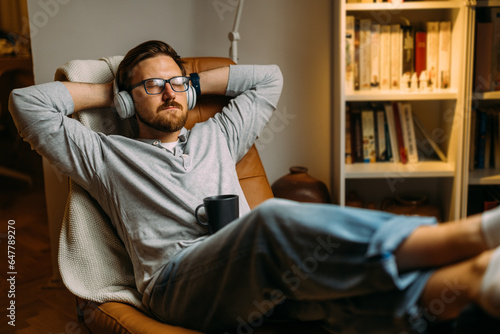 Caucasian man relaxes at home with music after a long day at work.