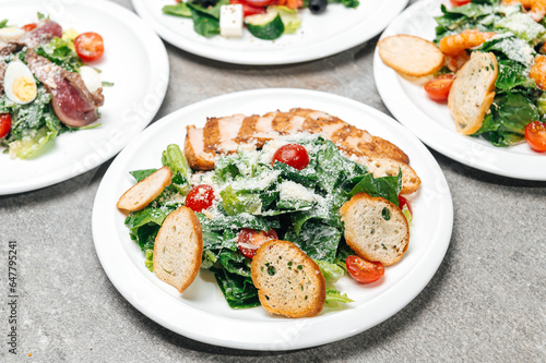 Plates with fresh salads with meat and shrimp