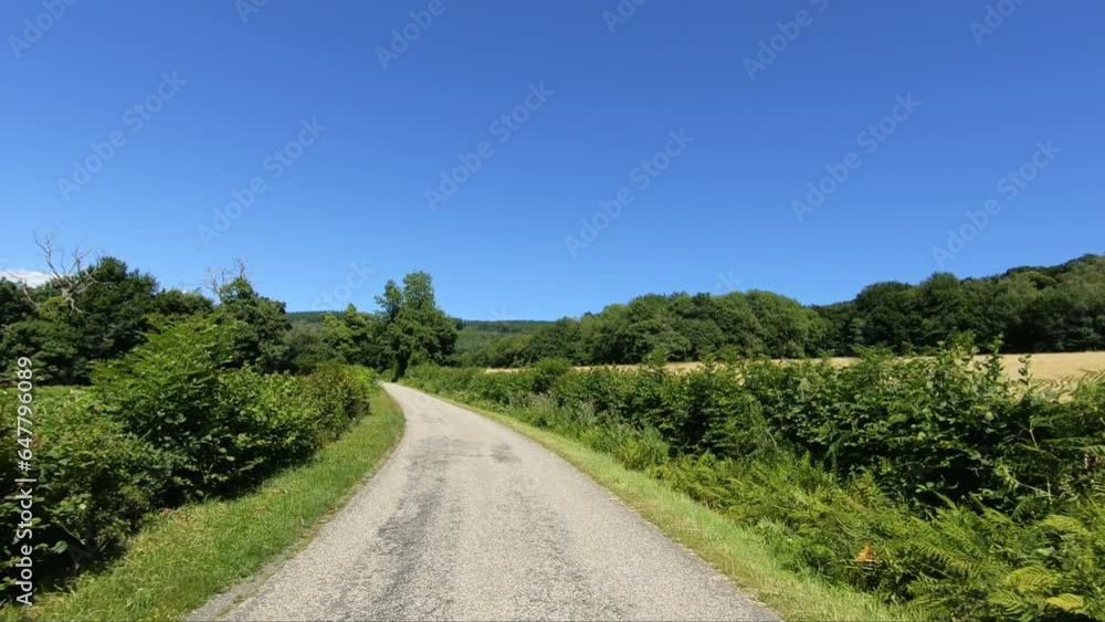 A track runs through green nature in Europe, France, Burgundy, Nievre, towards Chateau Chinon, in summer, on a sunny day. A track runs through green nature in Europe, France, Burgundy, Nievre, towards Chateau Chinon, in summer, on a sunny day.