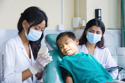 Happy Child in Dentist Office with Female Nurses and Doctors