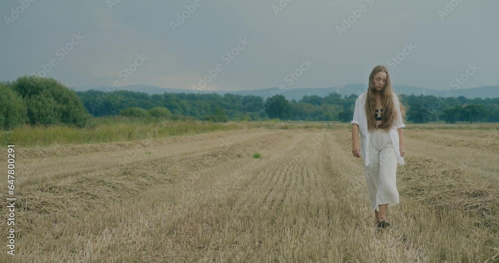 Woman Looking Away While Walking In Meadow Woman Looking Away While Walking In Meadow