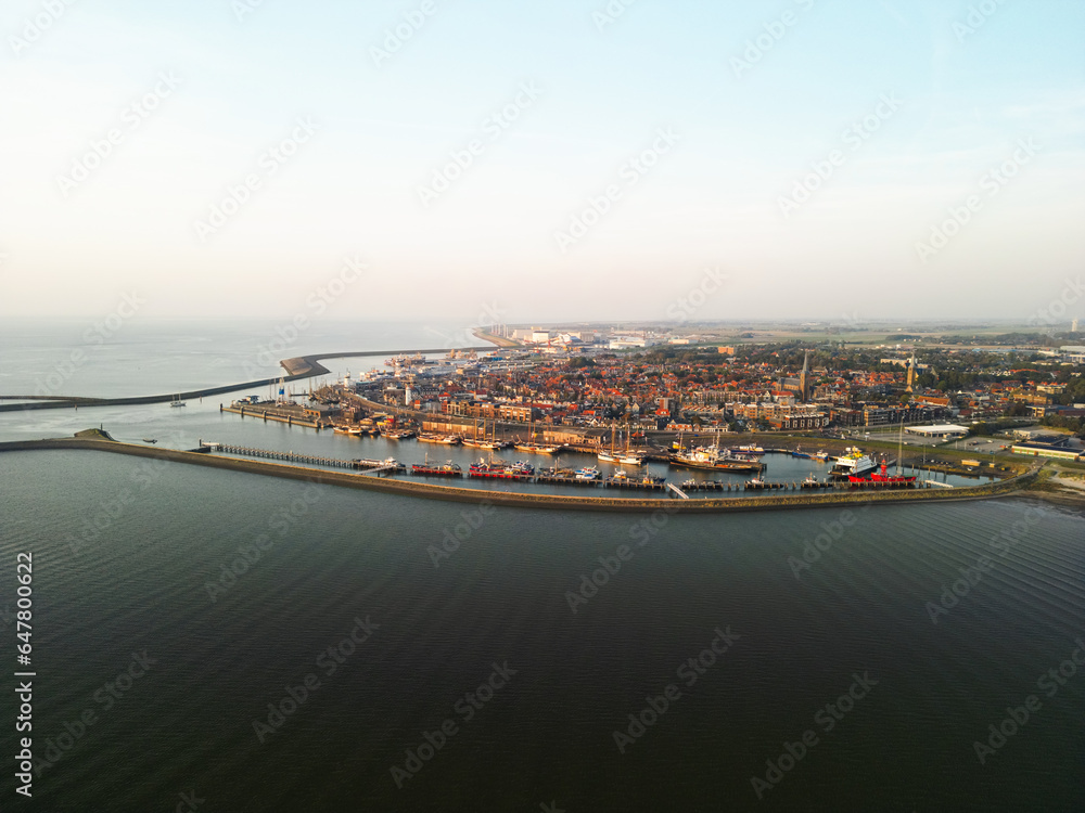 Fototapeta premium Aerial view of the city of Harlingen, at sunset in the IJsselmeer in the Netherlands.