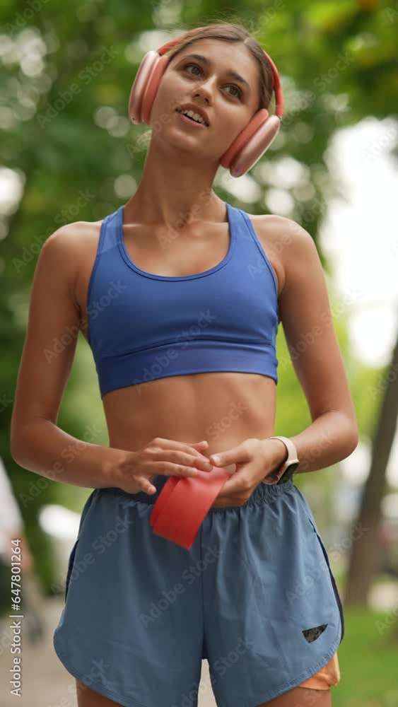A young woman in sportswear is warming up with a resistance band before her run. A young woman in sportswear is warming up with a resistance band before her run.