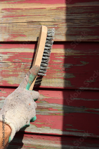 Wallpaper Mural Male hand wearing glove removes paint of the wooden wall using Wire Brush Paint Remover. Renovation concept.  Torontodigital.ca
