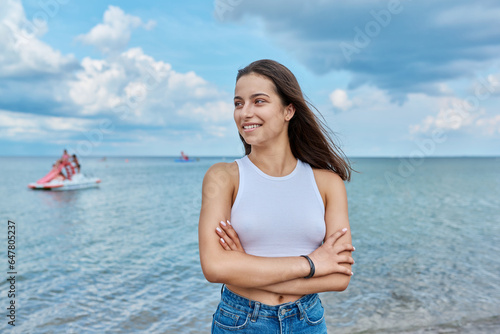 Portrait of smiling teenage girl outdoor on sea background