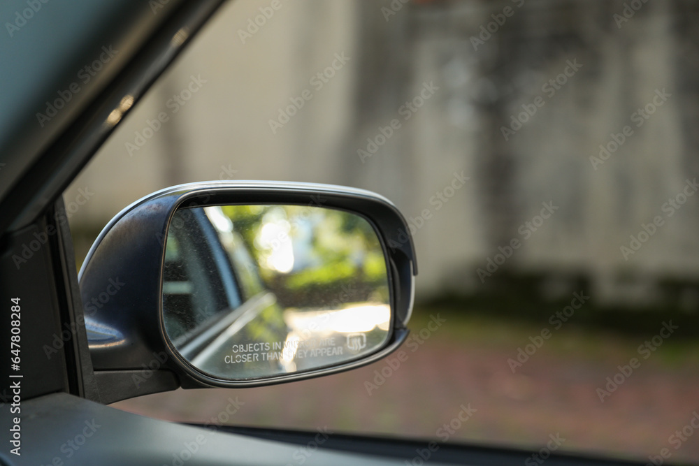 car's rearview mirror, reflecting a scenic road behind. The mirror symbolizes nostalgia, reflection, and the journey of life, capturing moments from the past car's rearview mirror, reflecting a scenic road behind. The mirror symbolizes nostalgia, reflection, and the journey of life, capturing moments from the past