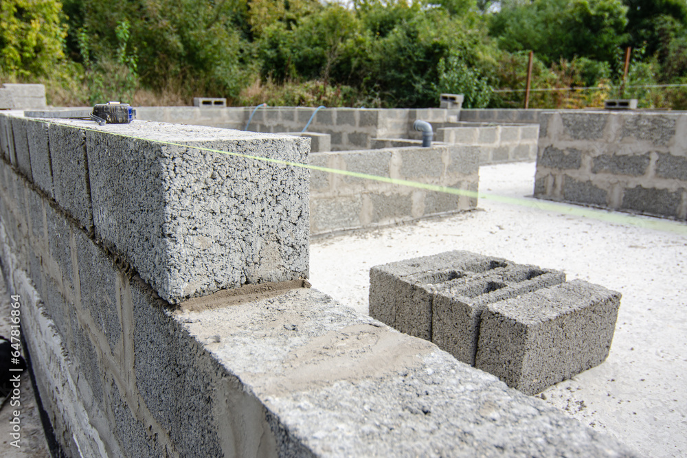 Stretched fishing line according to the level when laying expanded clay concrete blocks during the construction of a residential building Stretched fishing line according to the level when laying expanded clay concrete blocks during the construction of a residential building