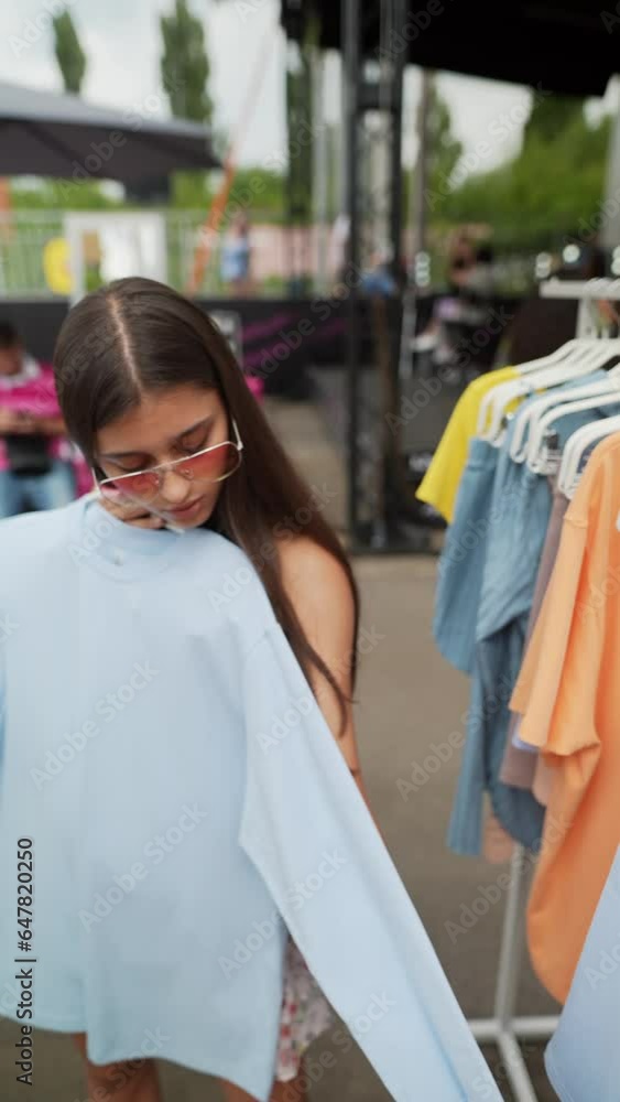 A bright young woman is selecting her attire at the summer festival. A bright young woman is selecting her attire at the summer festival.