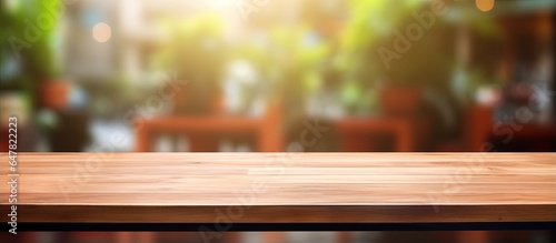 Empty wooden board on table with blurred interior of coffee shop as background product mock up