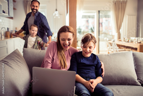 Young Caucasian family having fun and using a laptop at home