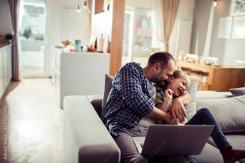 Young Caucasian father and daughter using a laptop at home Young Caucasian father and daughter using a laptop at home