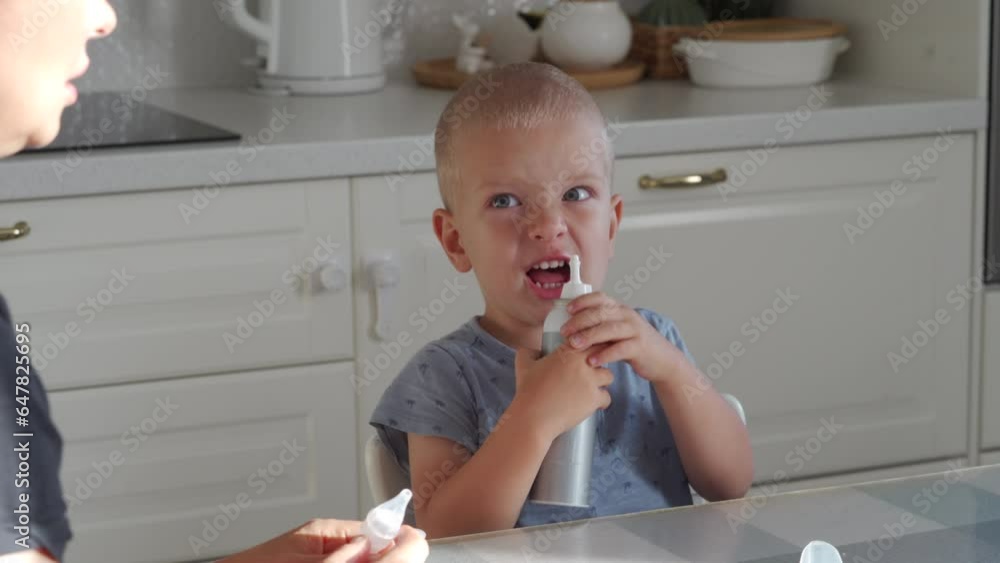 mother uses nasal aspirator baby snot sucker and nasal spray spraying