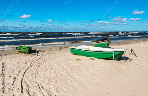 Coastal landscape in autumn with fishing boats anchored at sandy beach of the...