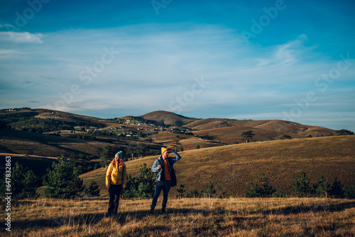 Couple of hikers walking on a mountain trail during their vacation