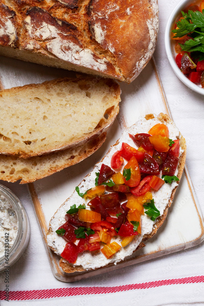 Bruschetta from homemade bread with cottage cheese and sprat pate and tomatoes on a wooden background. Rustic style.