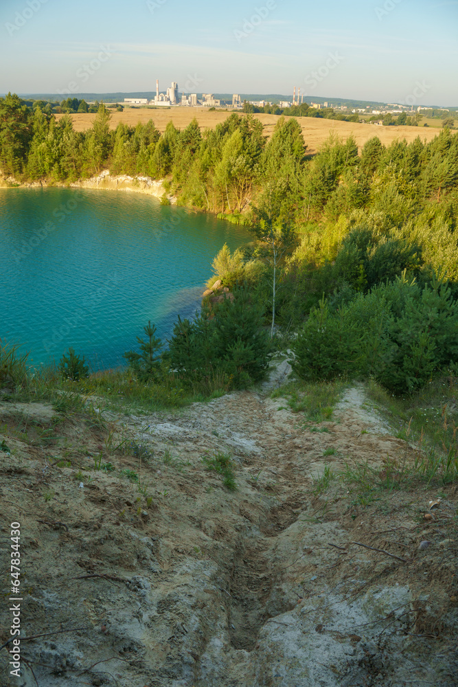 Obraz premium Aerial photography of a flooded sand pit from a drone. A sand mine for cement production. Beautiful industrial aeroplane. Mining industry. Mining with the help of a drone and modern technologies.