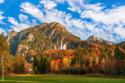 A breathtaking image of Neuschwanstein Castle, Germany iconic fairytale castle. Nestled in the mountains, the castle white facade stands out against the autumn backdrop