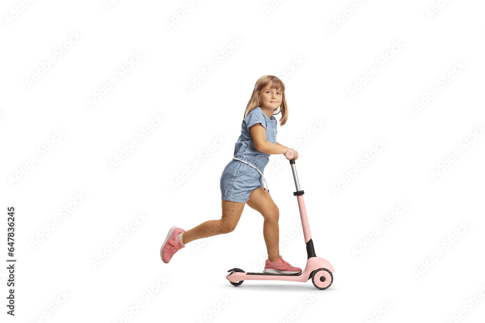 Full length shot of a girl riding a pink scooter and looking at camera Full length shot of a girl riding a pink scooter and looking at camera