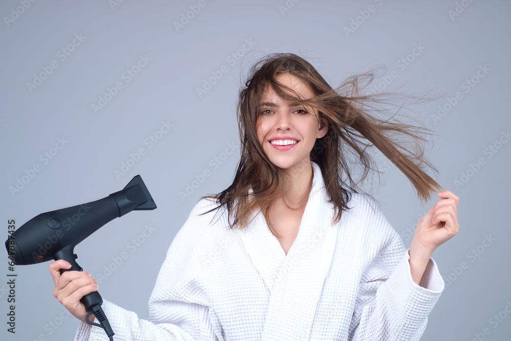 Woman with hairdryer isolated on studio background. Girl hold hairdryer. Young woman drying hairs with hair dry machine. Beauty girl using hair dryer. Beauti model with holding blow dryer. - obrazy, fototapety, plakaty 