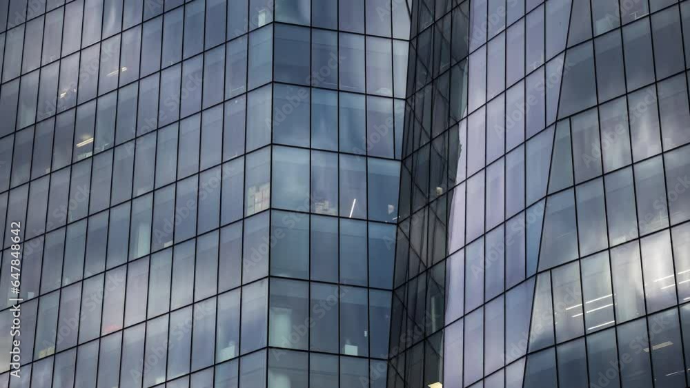 Timelapse reflection of moving white clouds and blue sky in glass wall of modern tall building, skyscraper - low angle view. Architecture, corporate, business, urban, time lapse, cityscape concept Timelapse reflection of moving white clouds and blue sky in glass wall of modern tall building, skyscraper - low angle view. Architecture, corporate, business, urban, time lapse, cityscape concept