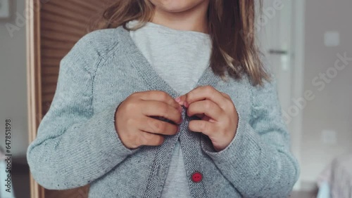 Close up hands button up skill for children, develop motor coordination, child practise buttoning grey jacket. kid learn functional dressing Montessory skills, sensory. get dressed lifedevelopmental. photo