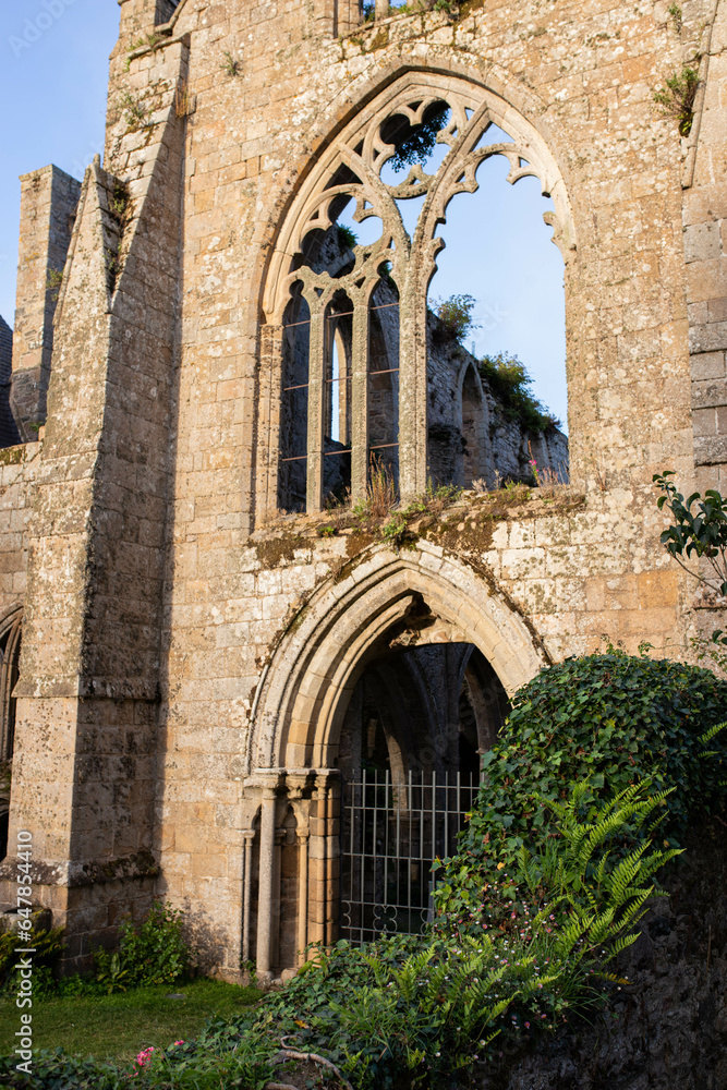 Detail of the main facade of Beauport Abbey, a roofless gothic building located in Paimpol, Cotes d'Armor, Brittany, France. August 2023, sunset view. Detail of the main facade of Beauport Abbey, a roofless gothic building located in Paimpol, Cotes d'Armor, Brittany, France. August 2023, sunset view.