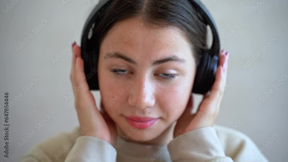 Young teen girl woman with headphones looking at camera smiling listen to music radio podcast, dance, enjoy life. Technology in daily life, Youth culture Young teen girl woman with headphones looking at camera smiling listen to music radio podcast, dance, enjoy life. Technology in daily life, Youth culture