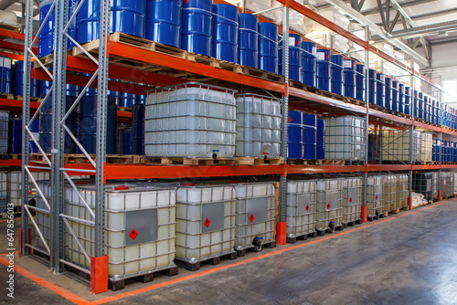 Petroleum products warehouse. Multi-tiered racks with barrels. Chemical company storage facility. Warehouse building interior. Chemical plant storage space. Petroleum products are stored on shelves