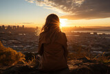 A young woman looks from a height on a beautiful city landscape against the backdrop of the setting sun. Generative AI.