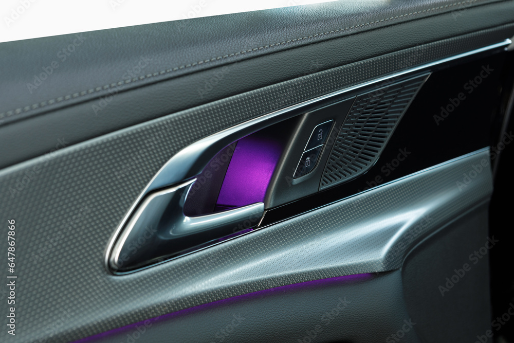 Door handle with windows control buttons of a luxury car. leather interior of the luxury modern car. Speaker and door panel