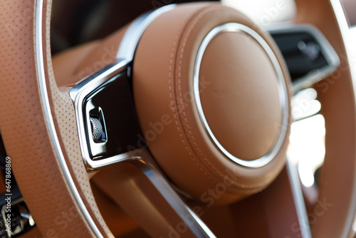 luxury car steering wheel with brown leather and touch control buttons © AvokadoStudio