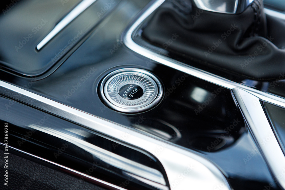 Engine Start Stop button on modern luxury car. black glossy design dashboard