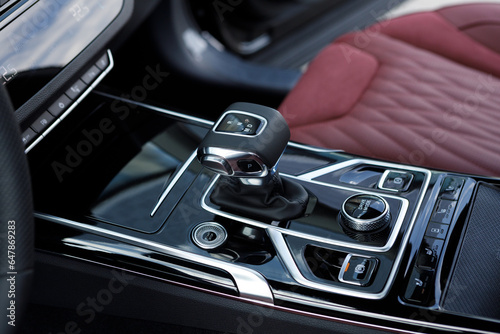 Automatic transmission selector with leather in the interior of a modern expensive car. Luxury car dashboard. Gear shift, car interior photo
