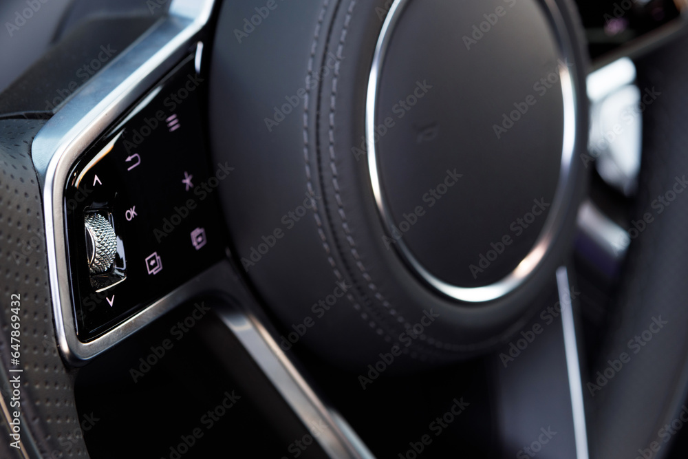Driving assistant fucntion buttons on multi-function steering wheel of the luxury car. Vehicle equipment part and object photo