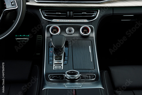Black wood, aluminum buttons, Automatic transmission, climate control and air vents in a modern car © AvokadoStudio