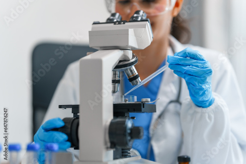 Fototapeta Naklejka Na Ścianę i Meble -  Young scientists pioneering medical discoveries in lab, with one scientist employing microscope for invaluable insights, blood lab test, virus vaccine invent, asian indian people