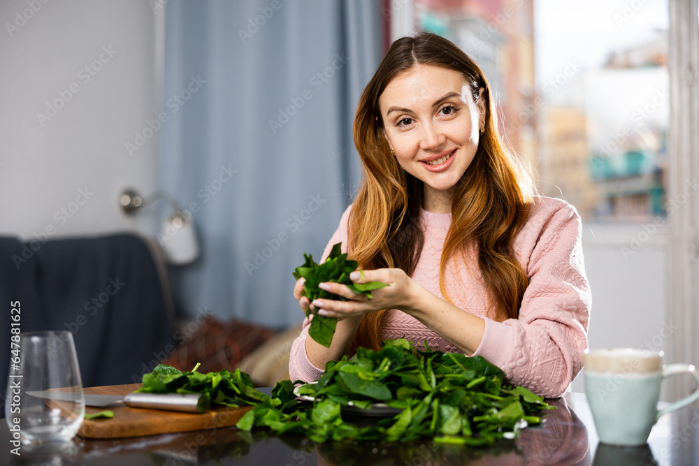 Happy girl making delicious spinach salad