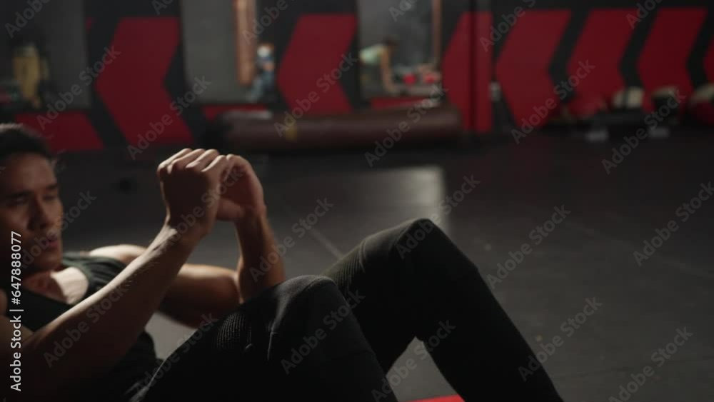 4K Strong Asian sportsman do sport training workout sit ups exercise on the floor at fitness gym. Active man bodybuilder athlete practicing muscular build body weight training at health club. 4K Strong Asian sportsman do sport training workout sit ups exercise on the floor at fitness gym. Active man bodybuilder athlete practicing muscular build body weight training at health club.