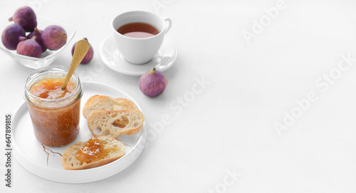Toasts, sweet fig jam and cup of tea on white background with space for text