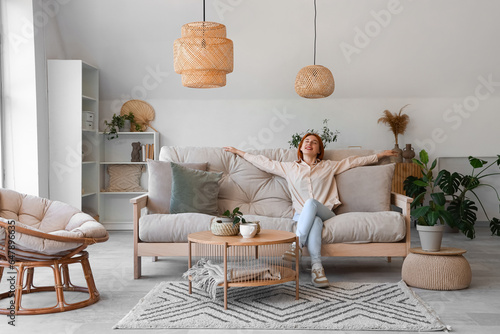 Young woman sitting on couch in living room