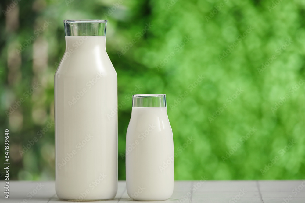 Bottles of fresh milk on white tile table outdoors Bottles of fresh milk on white tile table outdoors