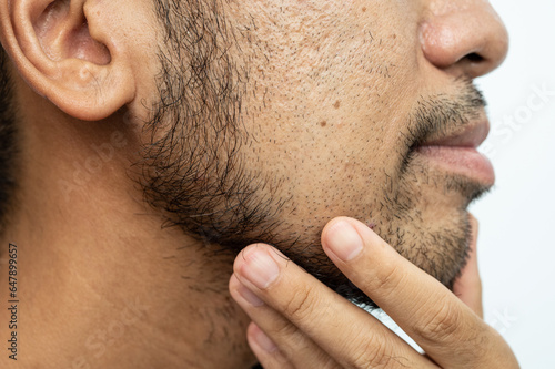 Side view of Asian man face with beard grows on his lower face. Beard is the collection of hair that grows on the chin, upper lip, cheeks and neck of humans.