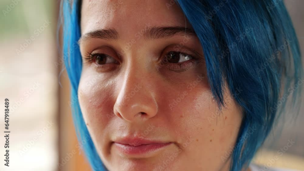 Very close portrait of face of young weeping woman, tears coming from
